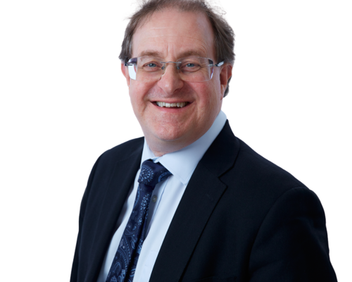 Headshot of Julian Flitter. White male with short dark hair. Wearing glasses, dark blue suit, light blue shirt and blue tie.