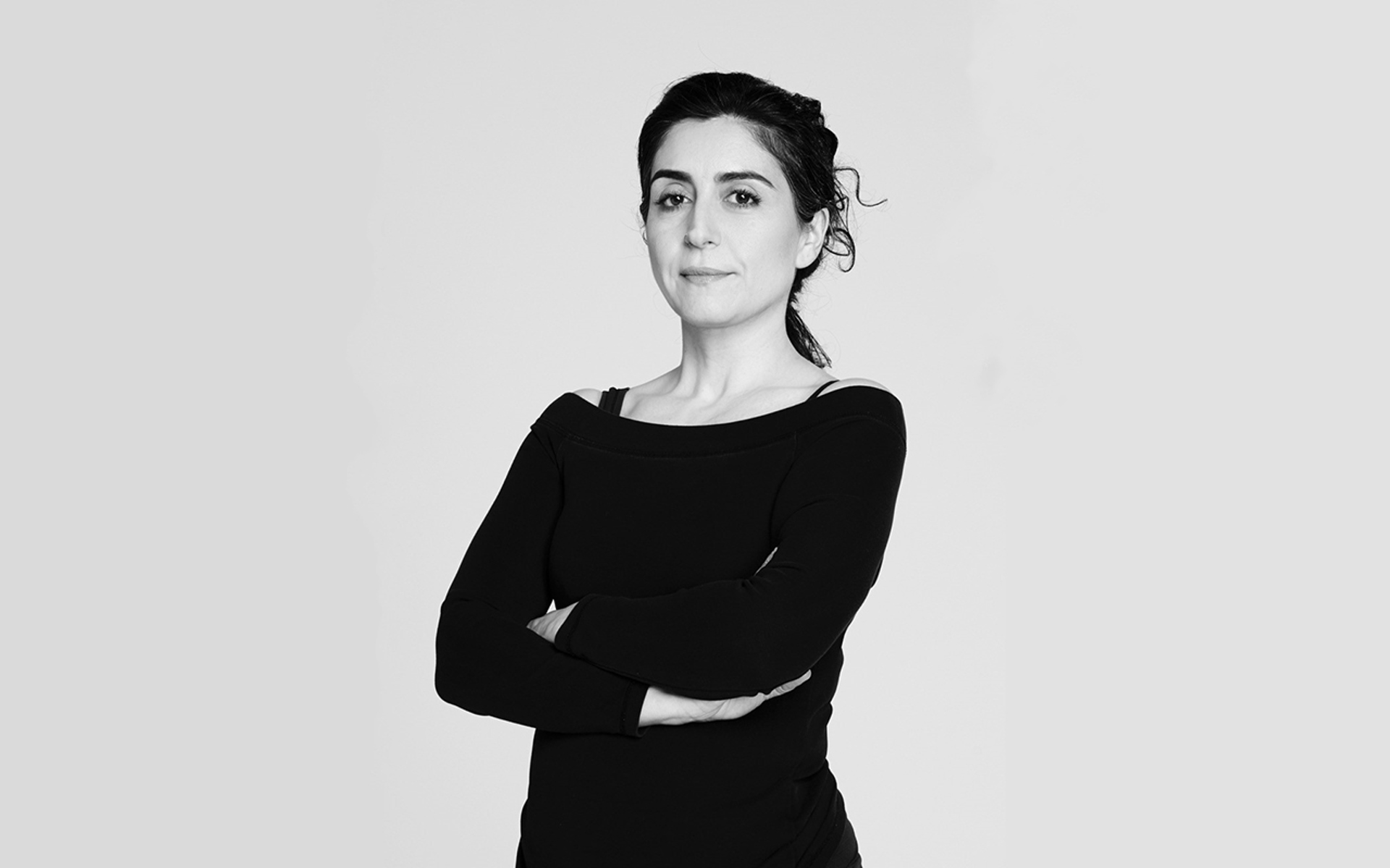 black and white headshot of Xenia Aidonopoulou. Female dancer with arms crossed