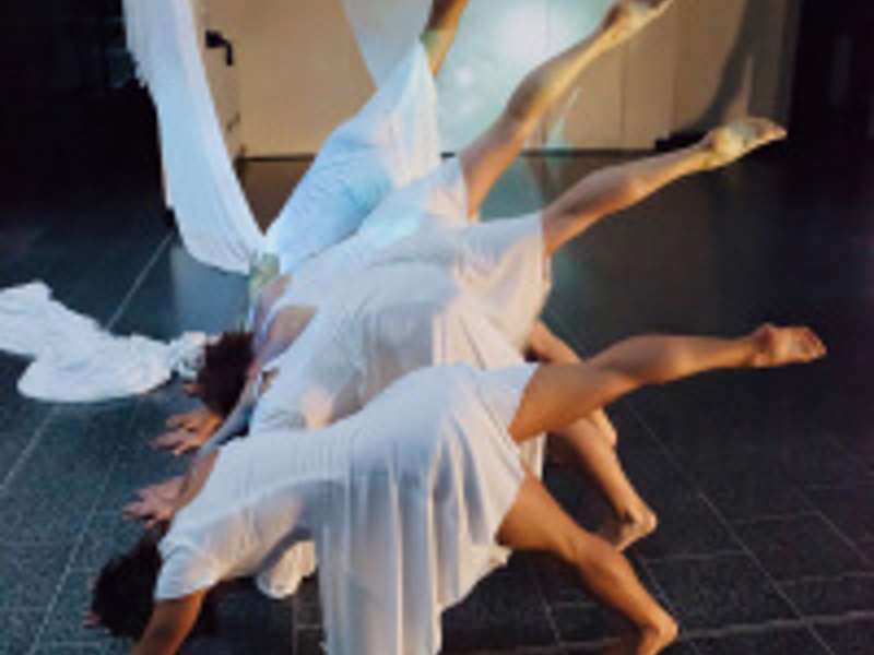 Four dancers starting a cartwheel wearing white dresses Four dancers starting a cartwheel wearing white dresses