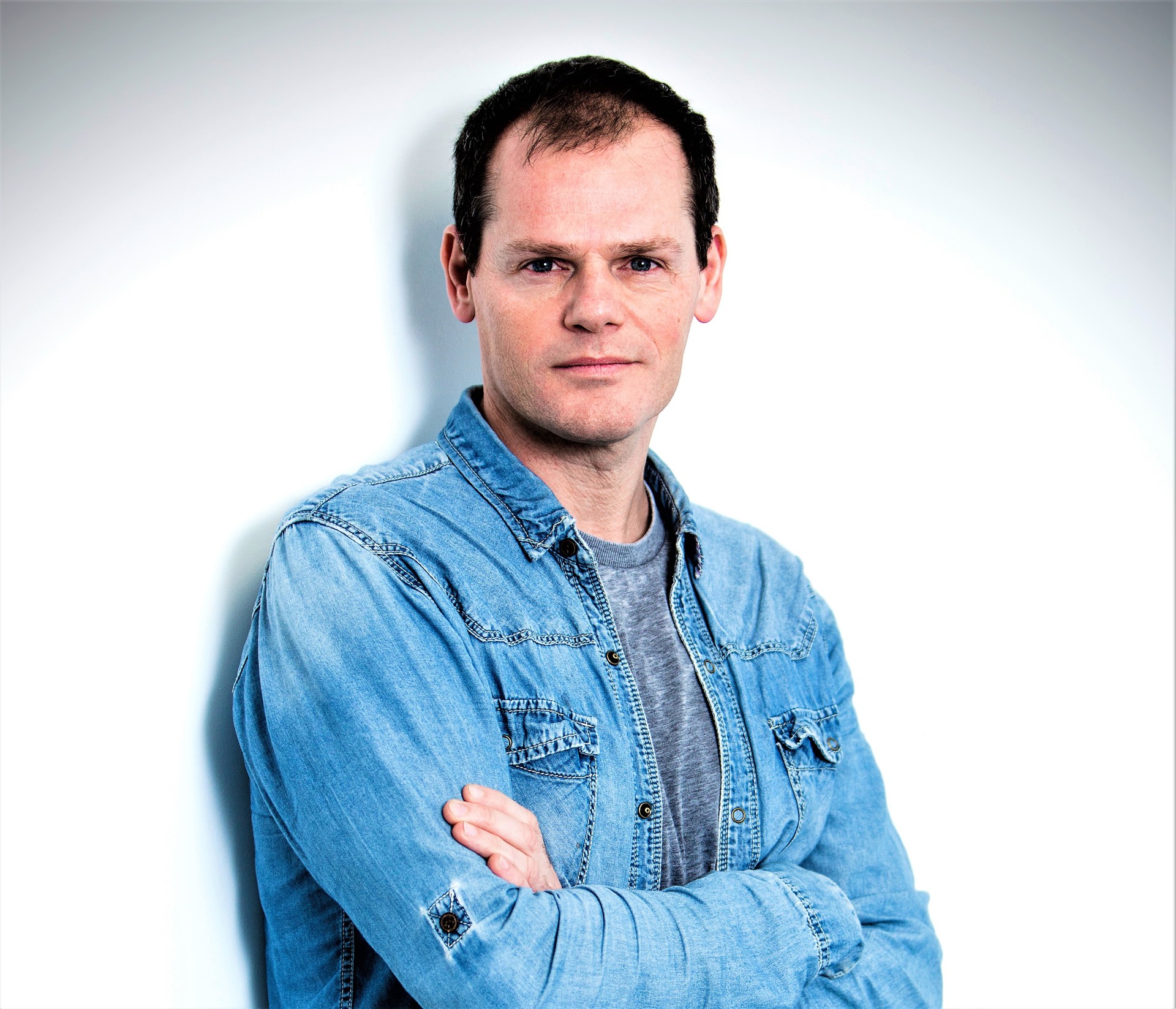 headshot of Luca Silvestrini. White male crossed arms looking at the camera with denim shirt