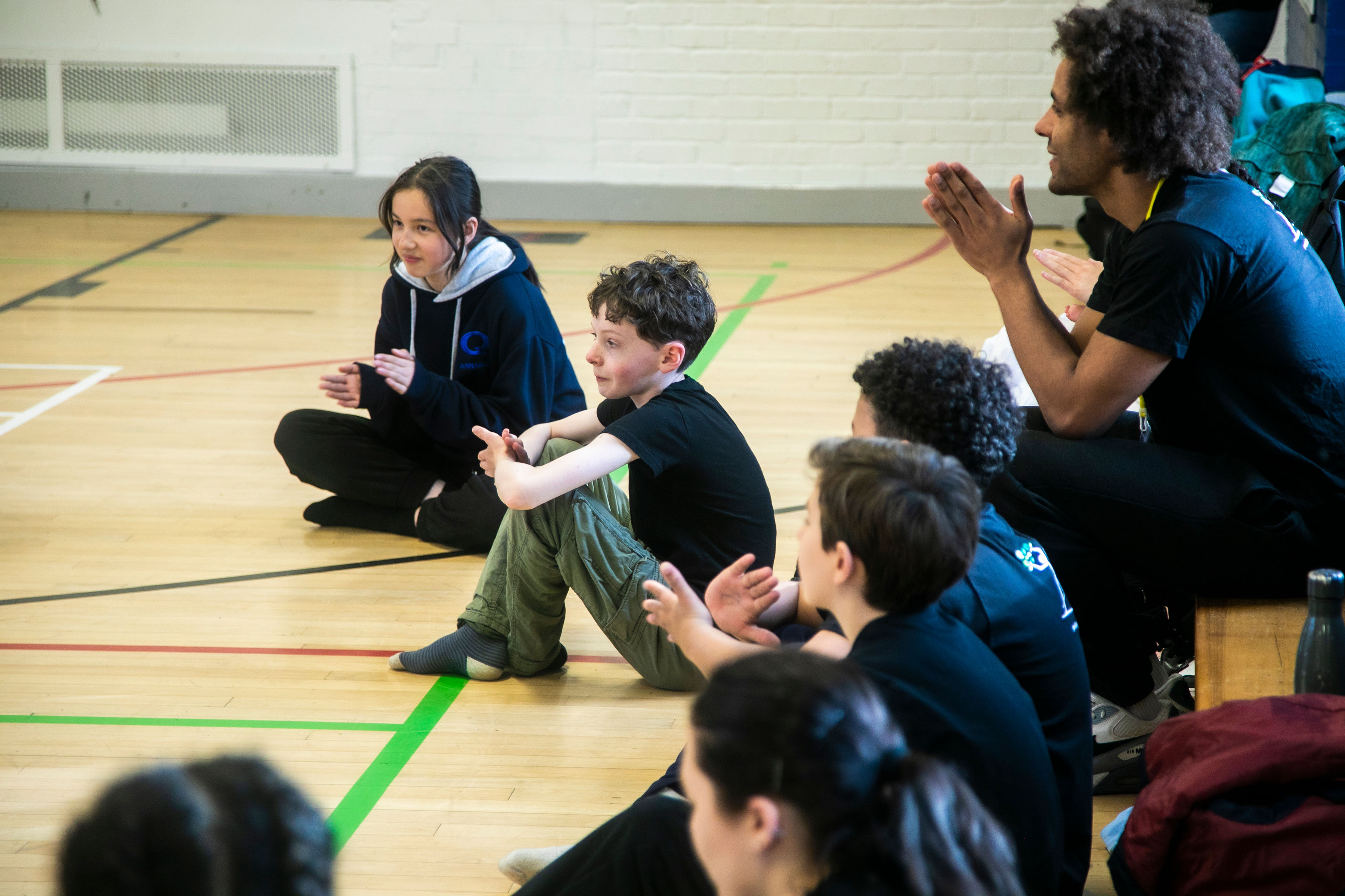 Dance students and their teachers applaud a performance in a sports hall Dance students and their teachers applaud a performance in a sports hall