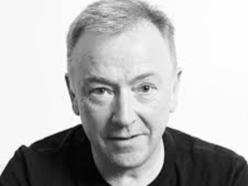 Headshot of Andrew Carrick. Black and white headshot of male with short hair wearing a black t-shirt.