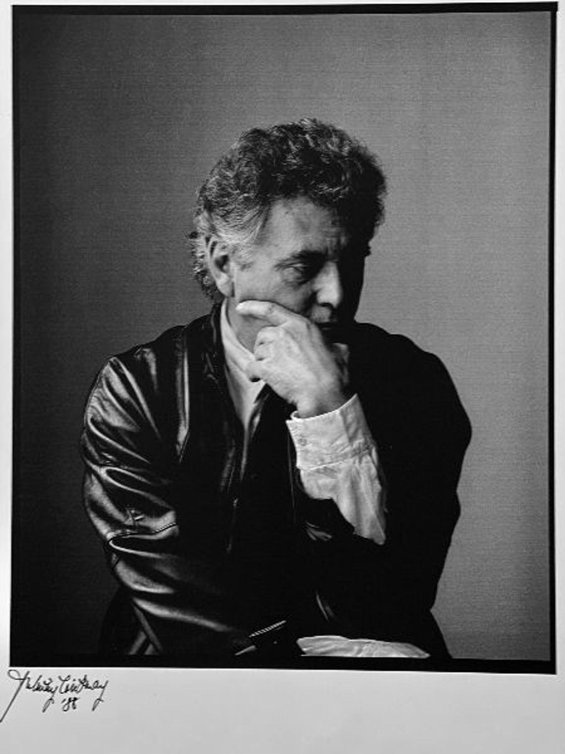 black and white headshot of a male holding his face and looking down black and white headshot of a male holding his face and looking down