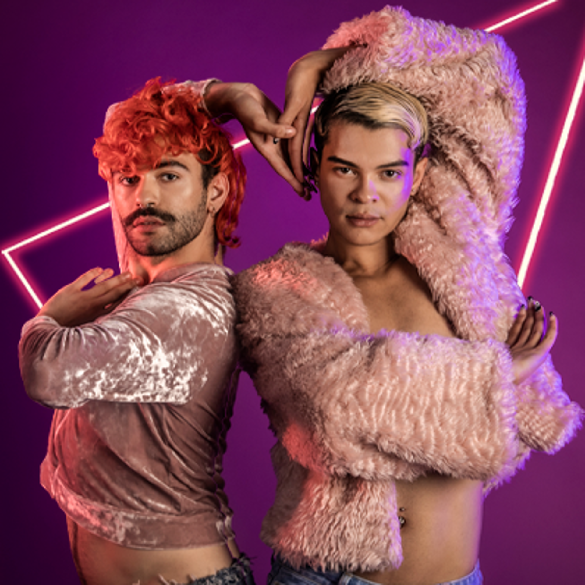 Two global majority LGBTQ+ male voguing dancers. Wearing pink tops in a purple studio. Standing next to eachother with outside hands leaning over their heads and joining together in the middle over eachother. Two global majority LGBTQ+ male voguing dancers. Wearing pink tops in a purple studio. Standing next to eachother with outside hands leaning over their heads and joining together in the middle over eachother.